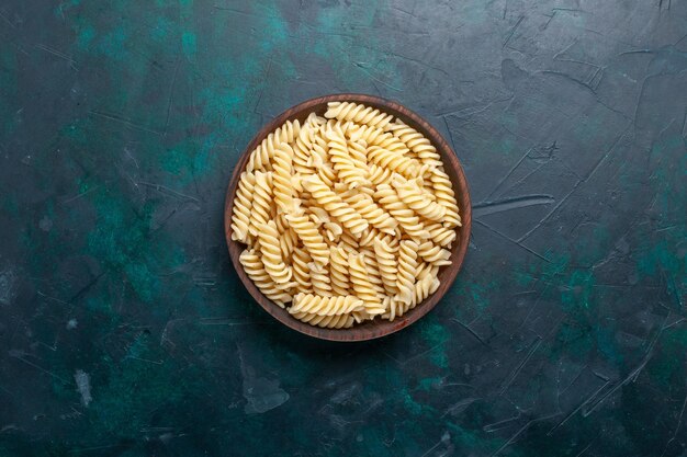 Vista superior de la pasta italiana deliciosa mirando dentro de una olla marrón en el escritorio azul oscuro pasta italiana comida cena cocinando masa