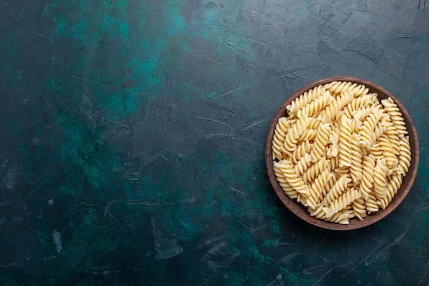 Vista superior de la pasta italiana deliciosa mirando dentro de una olla marrón en el escritorio azul oscuro pasta italiana comida cena cocinando masa