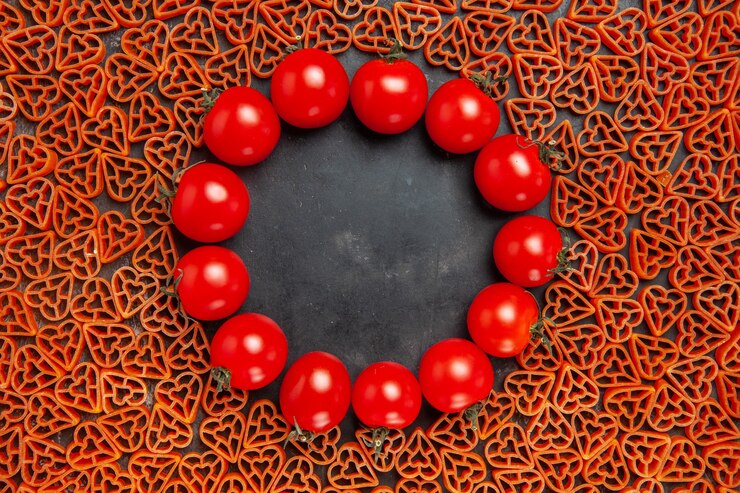 Foto gratuito vista superior de pasta italiana en forma de corazón en la mesa oscura