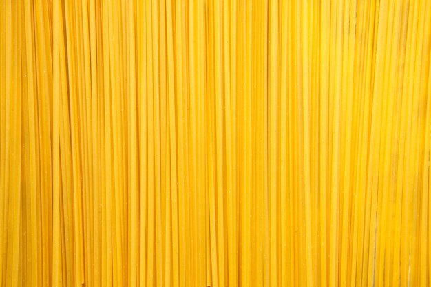 Vista superior de pasta italiana larga cruda sobre fondo claro