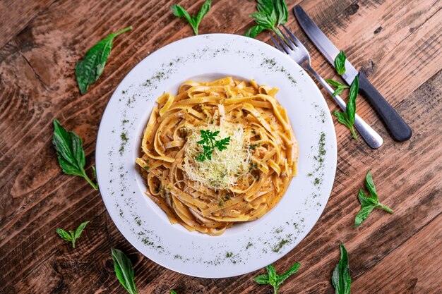 Vista superior de una pasta con queso en una placa blanca.