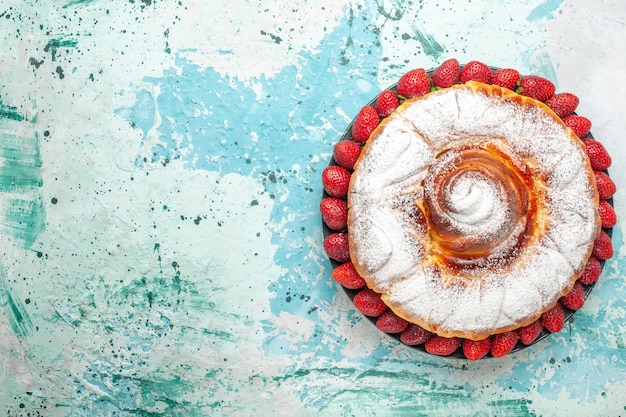 Foto gratuita vista superior de pastel de azúcar en polvo con fresas rojas frescas en la superficie azul claro