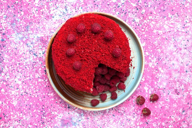 Vista superior del pastel de frambuesa roja al horno delicioso plato interior en la superficie rosa