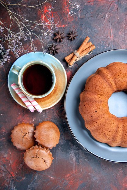 Vista superior de un pastel una taza de té azul plato de pastel tres apetitosos cupcakes canela anís estrellado