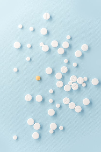 Vista superior de pastillas blancas con tableta amarilla