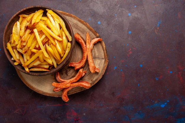 Vista superior patatas fritas sabrosas patatas fritas con salchichas en el escritorio oscuro