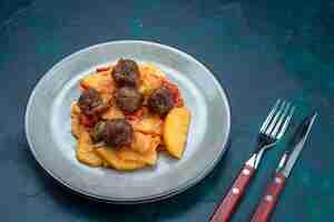 Foto gratuita vista superior de patatas en rodajas cocidas con albóndigas dentro de la placa sobre el fondo azul oscuro.