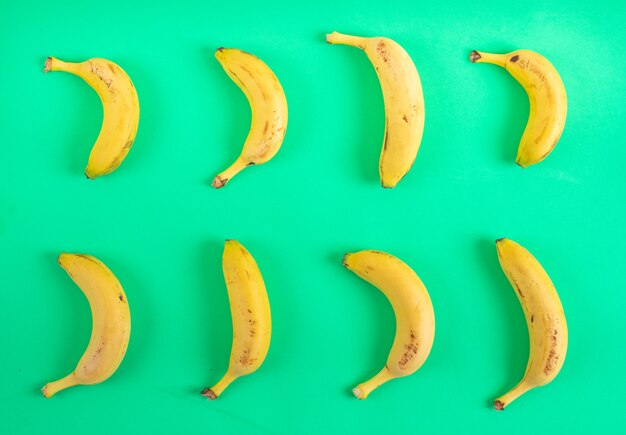 Vista superior del patrón de plátanos en superficie verde
