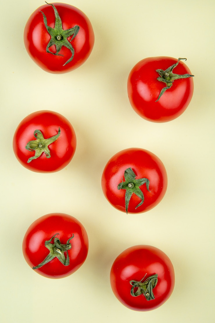 Foto gratuito vista superior del patrón de tomates en superficie amarilla