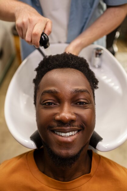 Vista superior peluquero lavando el cabello del hombre