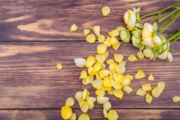 Vista superior de peonías maravillosas y frescas con pétalos amarillos sobre una superficie de madera