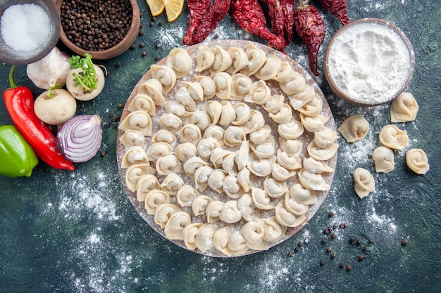 Foto gratuita vista superior de pequeñas albóndigas crudas con harina y verduras sobre fondo oscuro, masa de carne, plato de comida, comida calórica, color, hornear vegetales