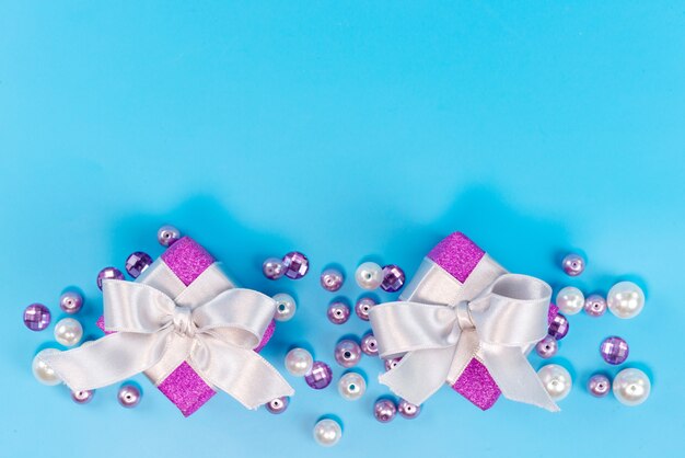 Una vista superior de pequeñas cajas púrpuras para cumpleaños aislado en azul, fiesta de celebración de cumpleaños