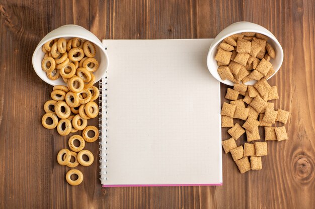 Vista superior de pequeñas galletas de almohada con galletas en el escritorio de madera marrón