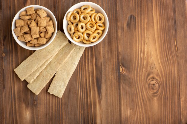 Vista superior de pequeñas galletas de almohada con galletas en el piso marrón