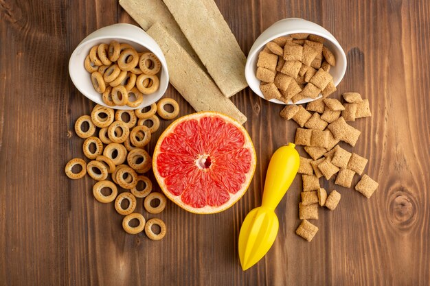 Vista superior de pequeñas galletas y galletas con pomelo en el escritorio de madera marrón