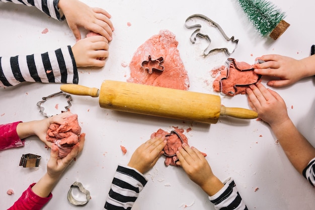 Foto gratuita vista superior de pequeñas manos haciendo galletas de navidad