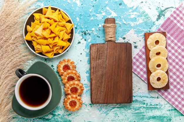 Vista superior pequeñas patatas fritas picantes con galletas saladas y galletas sobre fondo azul claro galleta galleta dulce azúcar té té