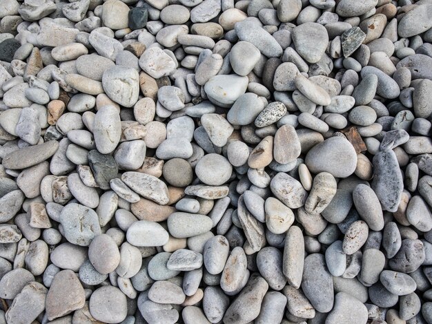 Vista superior de pequeñas piedras de cantos rodados en la playa durante el día