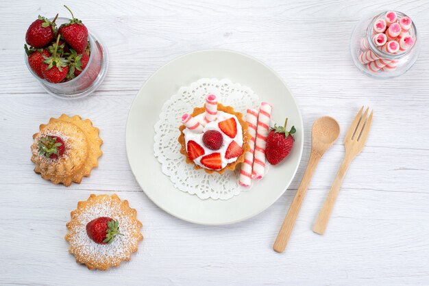 Vista superior del pequeño pastel con crema y fresas en rodajas tortas dulces en blanco, pastel de frutas baya dulce