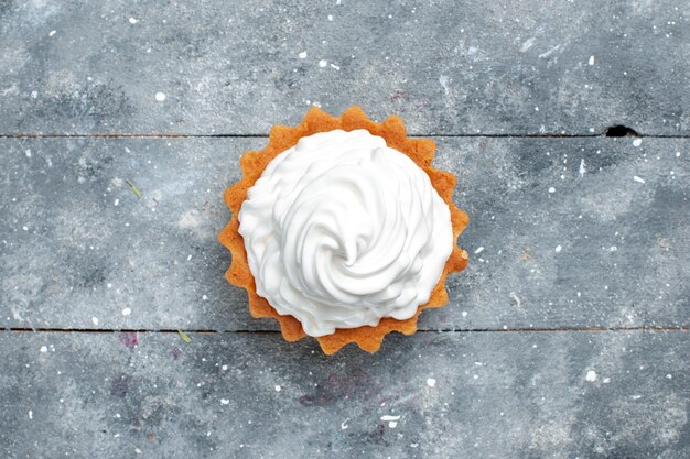 Vista superior pequeño pastel cremoso horneado delicioso aislado en el fondo gris pastel galleta dulce azúcar