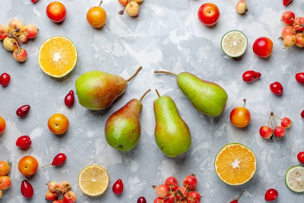 Vista superior de peras dulces con cerezas y limones en el escritorio de color blanco claro Fruta Berry Vitamina