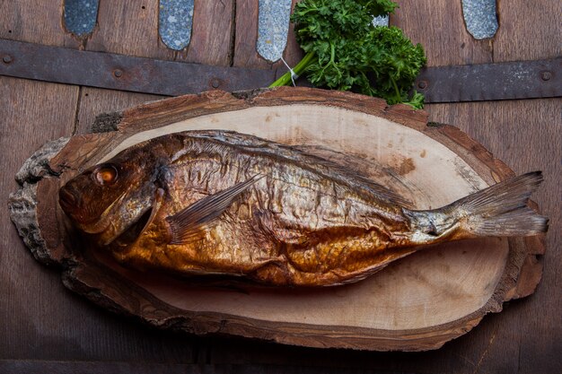 Vista superior de pescado ahumado con trozo de tronco