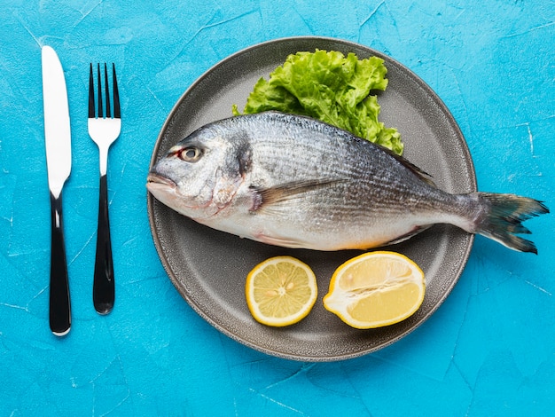 Vista superior de pescado con limón en un plato