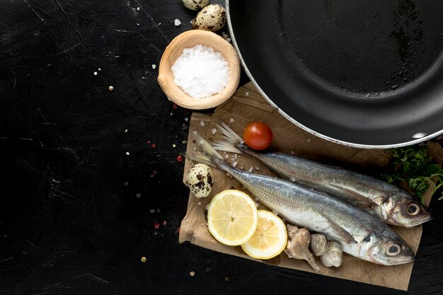 Vista superior de pescado con limón y sartén