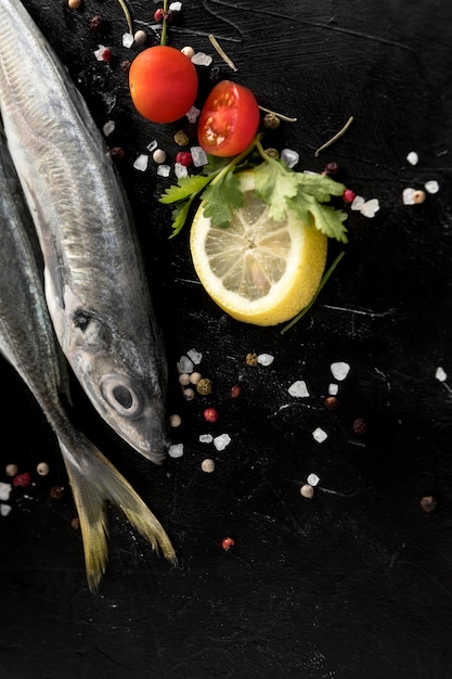 Vista superior de pescado con limón y tomates
