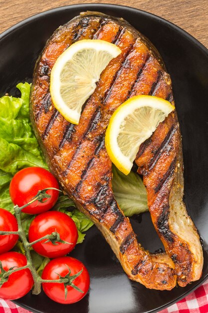 Vista superior de pescado a la plancha con rodajas de limón