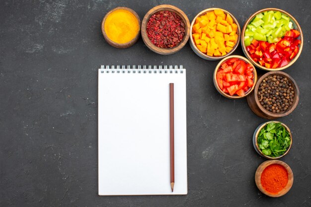 Vista superior de pimiento en rodajas con diferentes condimentos sobre fondo gris comida ensalada salud verduras picantes