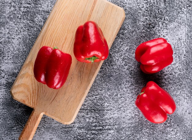 Vista superior pimiento rojo pimiento en tabla de cortar de madera en piedra gris horizontal