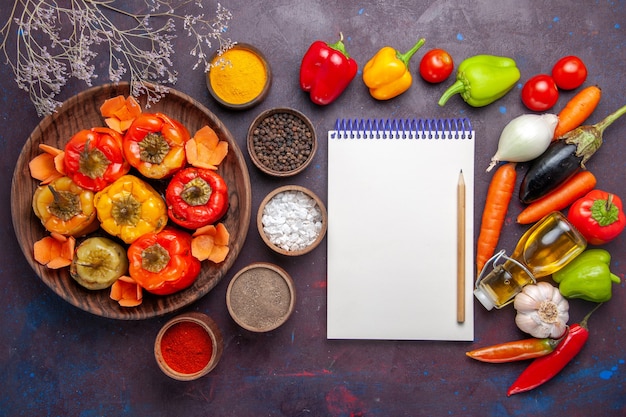 Vista superior de pimientos cocidos con condimentos y verduras frescas en la superficie gris comida verduras carne comida dolma