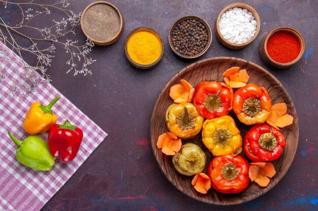 Vista superior de pimientos cocidos con diferentes condimentos en la superficie de color gris oscuro verduras carne dolma comida color comida calórica