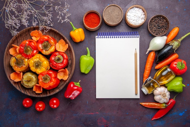 Vista superior de pimientos cocidos con verduras frescas y condimentos en la mesa gris comida dolma verduras carne de res