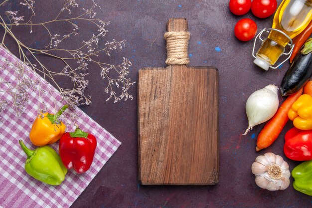 Vista superior de pimientos de colores con verduras frescas en la superficie gris pimiento vegetal picante comida picante