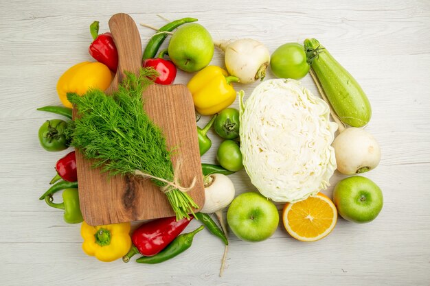 Vista superior de pimientos frescos con manzanas, repollo y verduras sobre fondo blanco ensalada de color maduro dieta de vida saludable