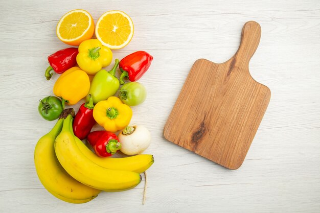 Vista superior pimientos frescos con plátanos sobre fondo blanco foto frutas comida color ensalada madura madura