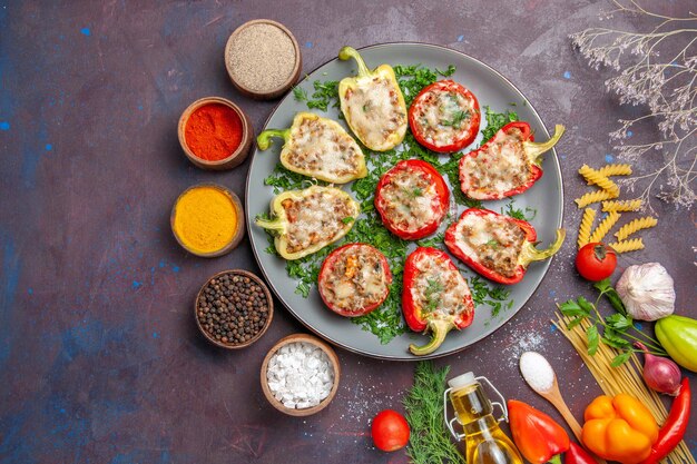 Vista superior de pimientos horneados deliciosa comida con carne en el interior y condimentos sobre fondo oscuro comida cena comida hornear plato