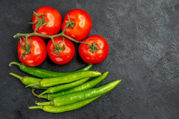 Vista superior de pimientos picantes verdes con tomates rojos