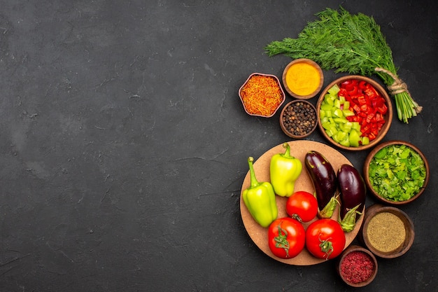 Vista superior de pimientos en rodajas con verduras y verduras en la superficie oscura producto comida comida ensalada salud