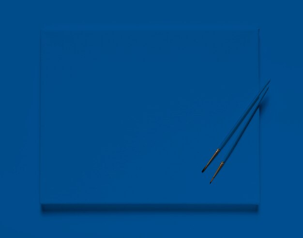 Vista superior de pinceles sobre lienzo de azul clásico