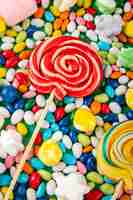 Foto gratuita vista superior de piruletas de colores sobre dulces en fondo de esmalte multicolor