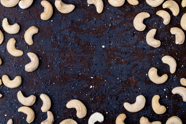 Vista superior de pistachos tostados salados aislados sobre fondo negro con espacio de copia