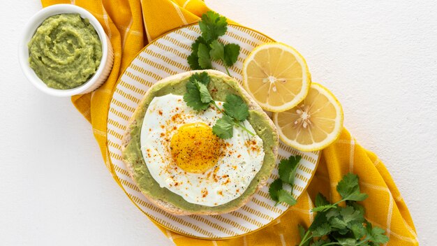 Vista superior de pita con untar de aguacate y huevo frito en un plato