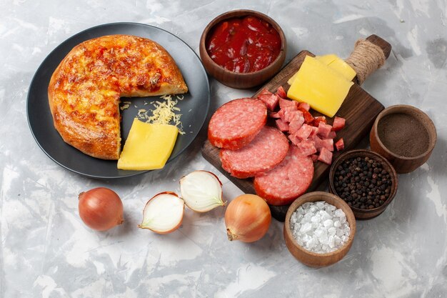 Vista superior de la pizza al horno con condimentos y salchichas en blanco