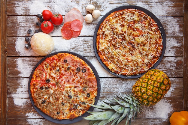 Foto gratuita vista superior de pizzas italianas de cuatro estaciones y pizzas hawaianas