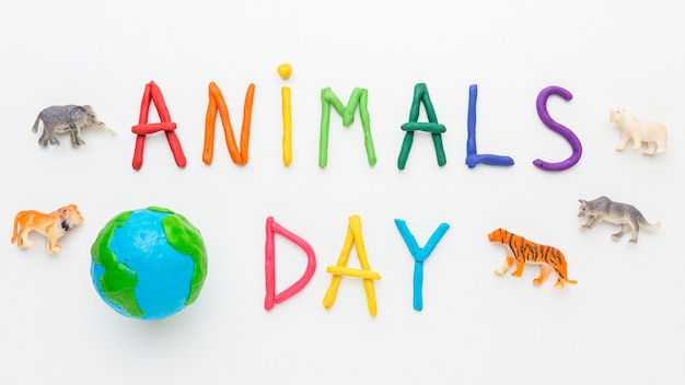 Vista superior del planeta tierra con figuras de animales y escritura colorida para el día de los animales