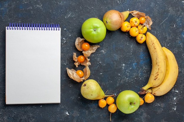 Foto gratuita vista superior de plátanos amarillos par de bayas con manzanas verdes frescas, peras, cerezas dulces, bloc de notas en el escritorio azul oscuro, fruta, baya, salud fresca, vitamina